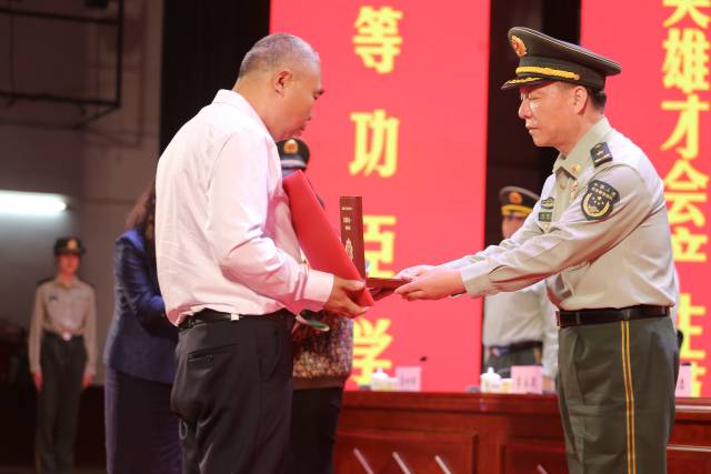 汪晓龙家属接过一等功奖章及奖励证书