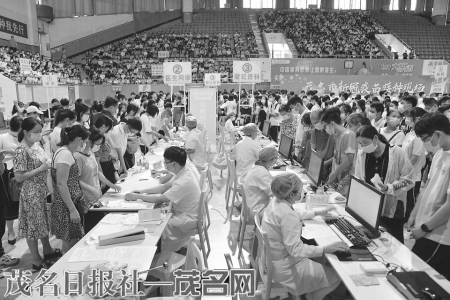 在市体育中心，家长带着孩子在排队登记，准备疫苗接种。<br>　　茂名日报社全媒体记者丘立贺通讯员卢睿琦摄<br>