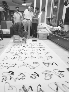 吴兆奇演示巨幅书法作品的创作过程。<br>