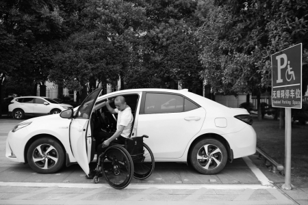 　　8月25日，刘毅在湖南省长沙市湘府文化公园无障碍停车位停车后坐上轮椅。无障碍停车位比一般停车位更宽，方便残疾人上下轮椅。 新华社记者薛宇舸摄<br>