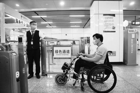 　　8月25日，伍树林（右）在湖南省长沙市桂花坪地铁站通过绿色通道进站乘车。新华社记者薛宇舸摄<br>