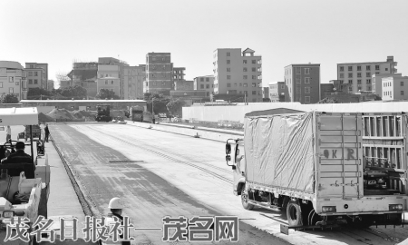施工人员在站前大道南段摊铺沥青。<br>